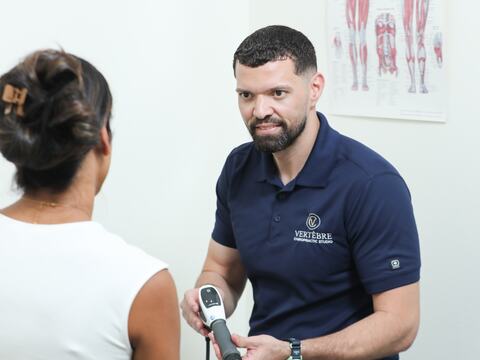 Dr. Toro giving a seated instrument adjustment to a patient's neck