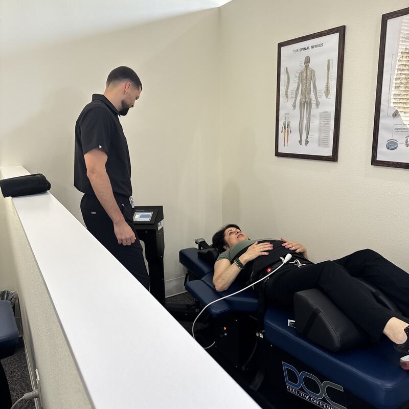 A patient in the harness on the spinal decompression table at Vertebre Chiropractic Studio in Winter Garden